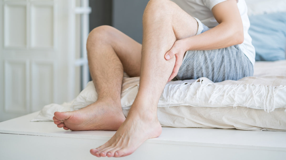 sportif se massant les mollets après l'entraînement, massage de récupération musculaire Image