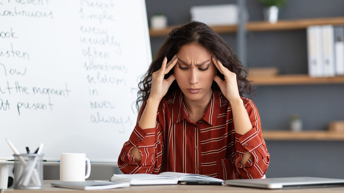 femme fatiguée, mains sur les tempes, tensions cervicales chroniques qui s'étendent Image
