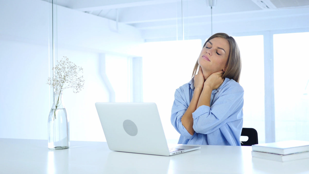 femme se tenant la nuque, tensions cervicales après journée de travail Image